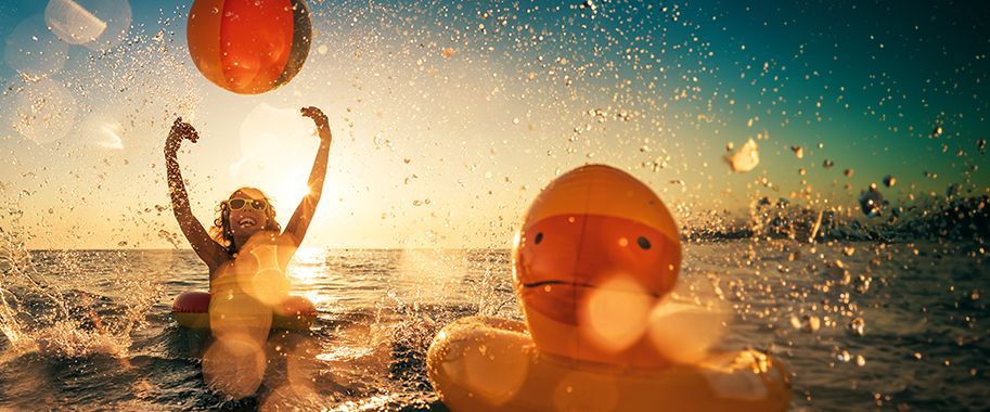 Kinder spielen mit Wasserbällen im Bodensee